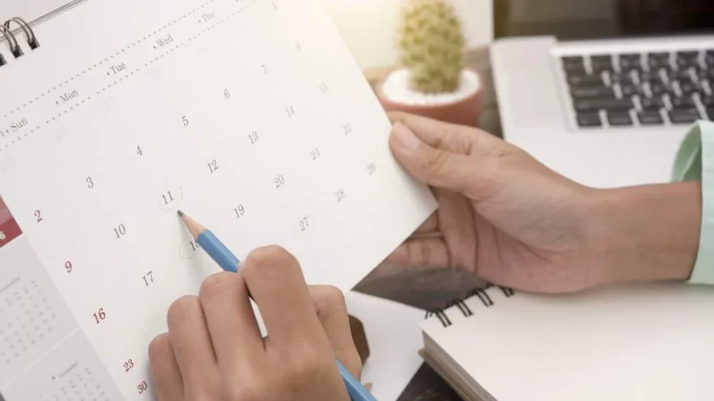 Imagem Maos anotando datas em um calendario do artigo Conheça as devoções para cada mês vividas pela Igreja
