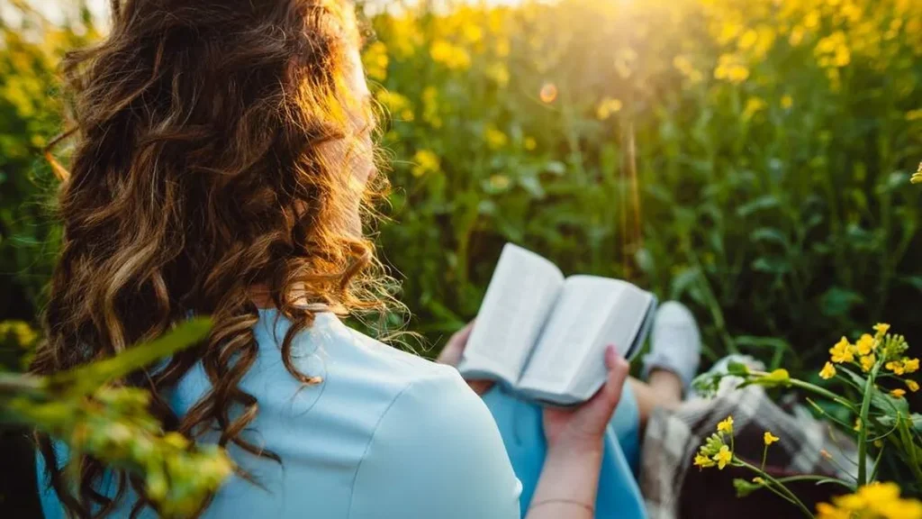 Imagem jovem lendo a biblia no jardim do artigo 12 versículos bíblicos para começar bem a semana