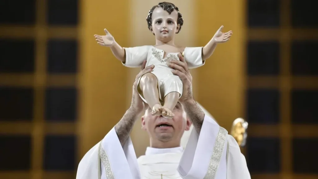 Imagem padre fabio evaristo segura a imagem do menino jesus durante missa de natal do artigo Qual o significado e até quando vai a Oitava de Natal?