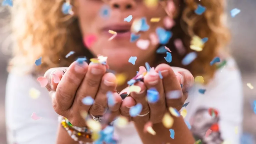 Imagem carnaval mulher assoprando papeis coloridos do artigo Carnaval: é possível se divertir sem pecar?