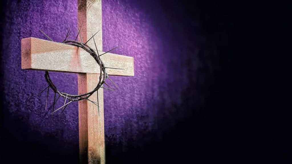 Imagem cruz catolica com a coroa de espinhos pendurada em um de seus lados e com fundo roxo de quaresma do artigo Que dia termina a Quaresma?