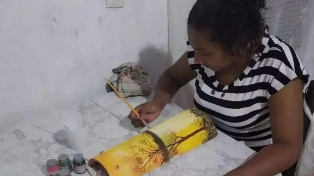 Sueli mostra com alegria a pintura que fez na oficina de artes