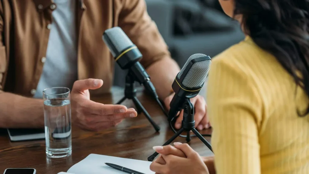 Imagem visao recortada de dois apresentadores de radio gravando podcast no estudio de transmissao do artigo Pontifícias Obras Missionárias (POM) lançam podcast