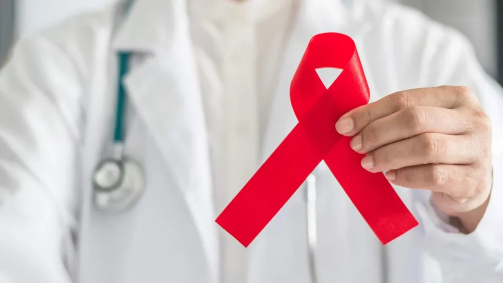 Imagem Medico segurando o simbolo de combate a AIDS do artigo Dezembro Vermelho: junte-se à luta contra a AIDS