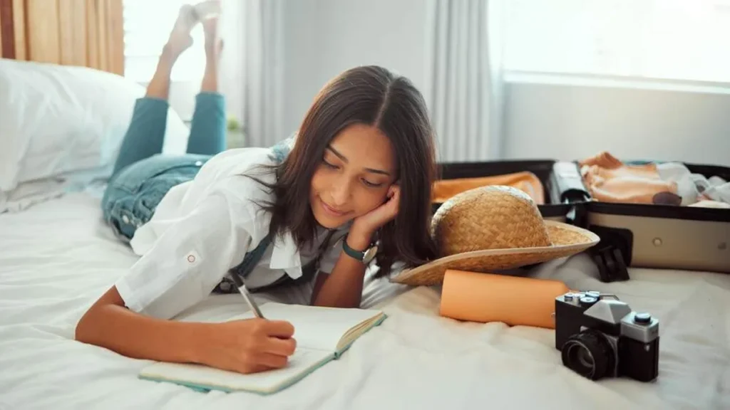 Imagem moca deitada na cama fazendo lista do artigo Liste seus sonhos para 2023 agora!