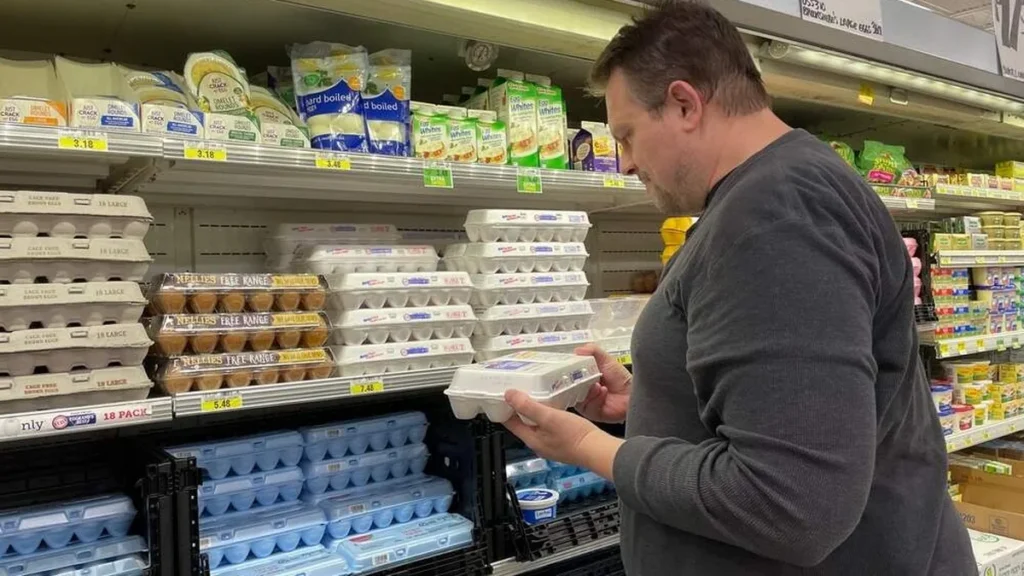 Imagem homem no supermercado conferindo ovos do artigo Inflação: como economizar no supermercado?