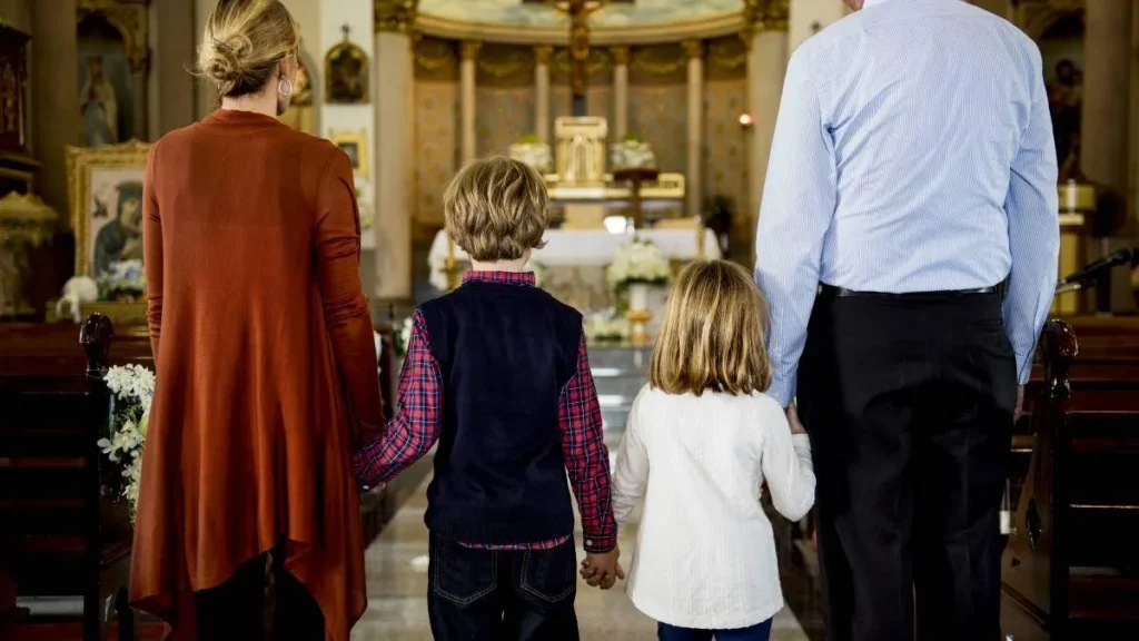 Imagem familia de costas olhando para o altar da igreja do artigo Igreja tem novos veneráveis: entre eles uma leiga, mãe de quatro filhos