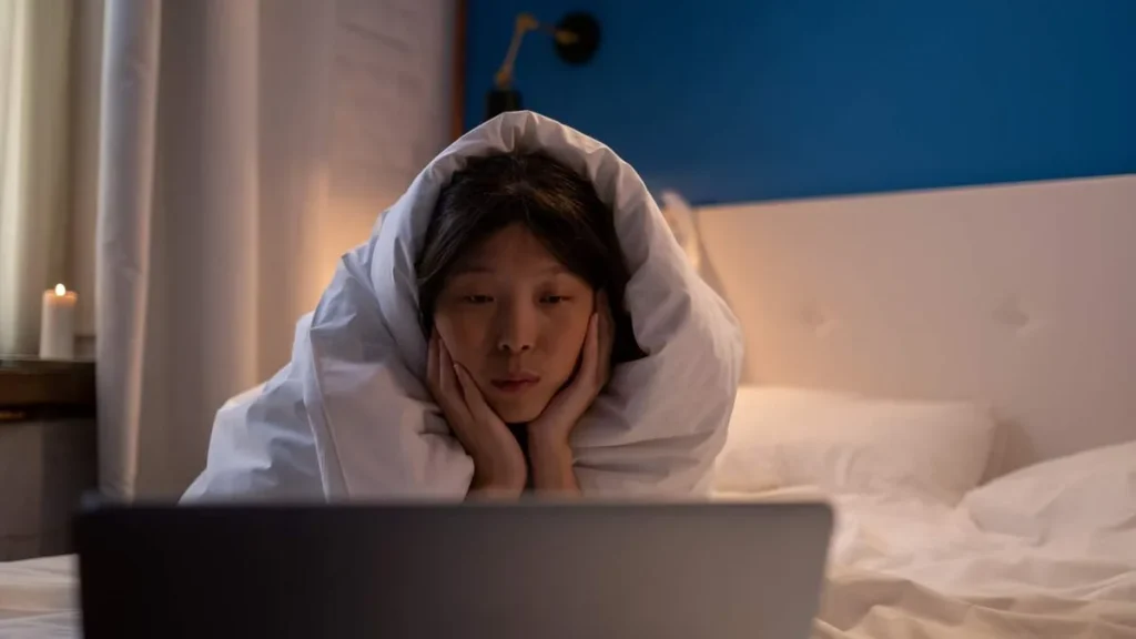 Imagem moca assistindo filme no notebook do artigo 5 filmes que retratam deficiências auditivas
