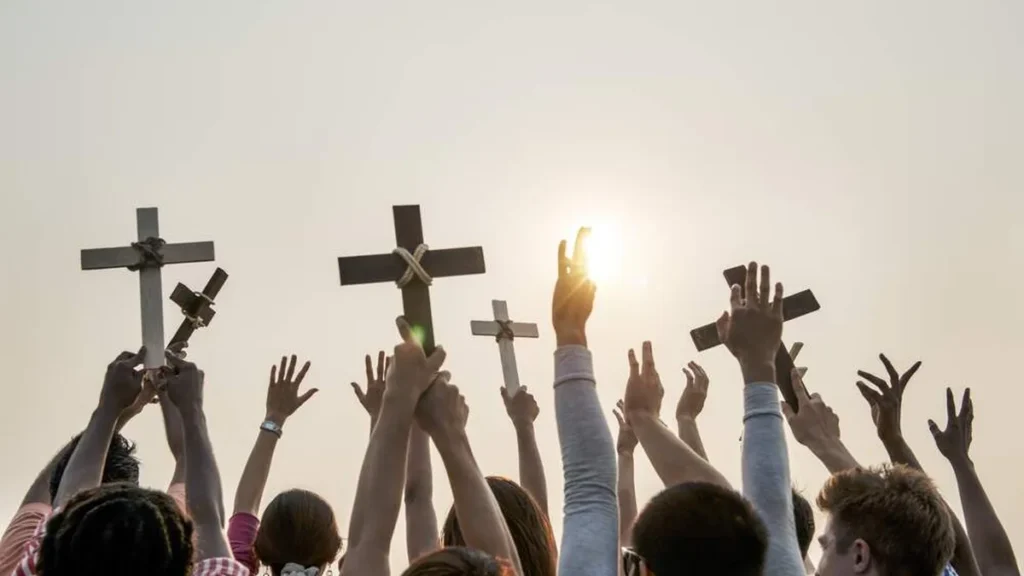Imagem jovens com as maos levantadas segurando cruzes do artigo “Os jovens da Igreja podem ser fermento”, diz Dom Odelir José Magri