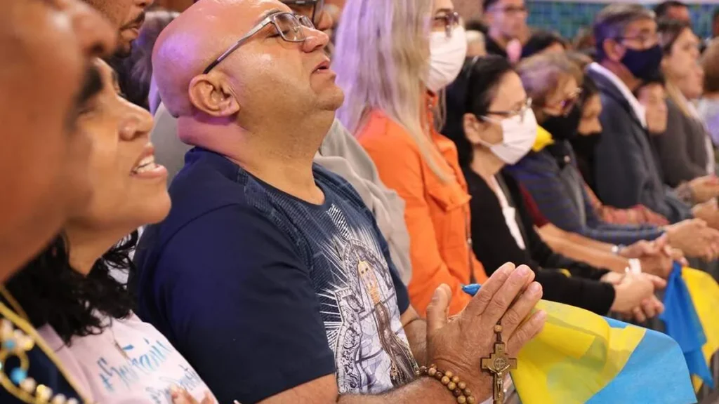 Imagem Homem rezando na Romaria da Familia dos Devotos do artigo “Construir com amor!”: Venha para 14ª Romaria da Família dos Devotos!