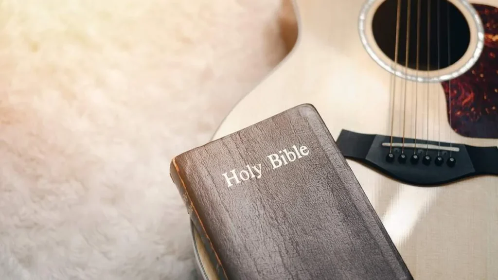 Imagem biblia em cima de um violao do artigo Essas 5 músicas de rock foram inspiradas na Bíblia!