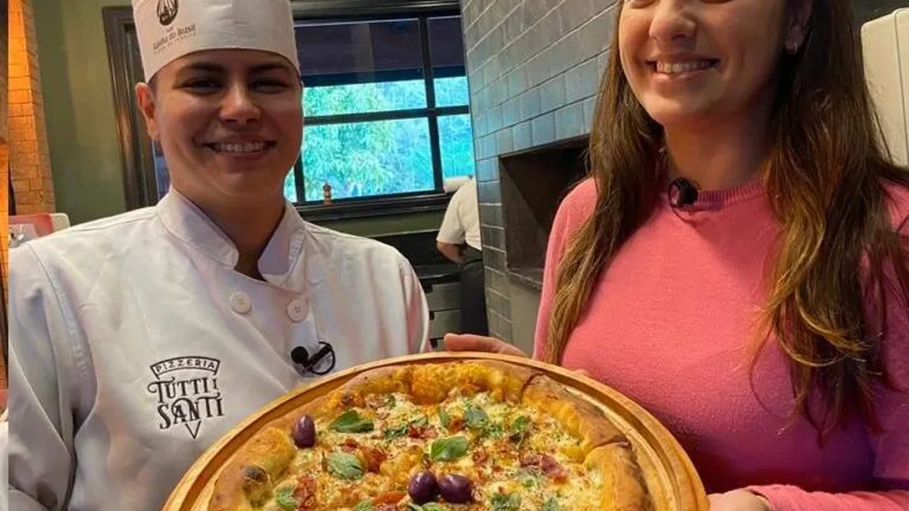 Locutora Raiane Brancatti experimenta pizza da Pizzeria Tutti i Santi na Cidade do Romeiro