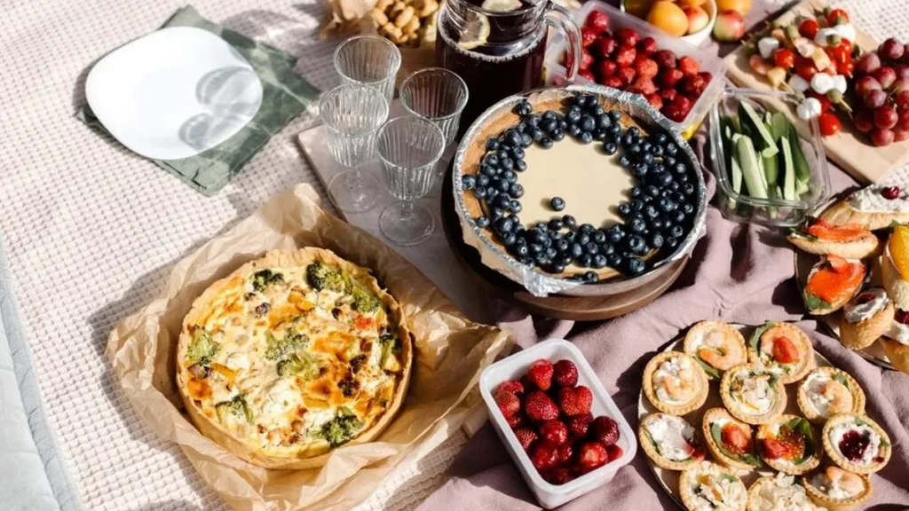 Mesa de piquenique posta com tortas doces e salgadas