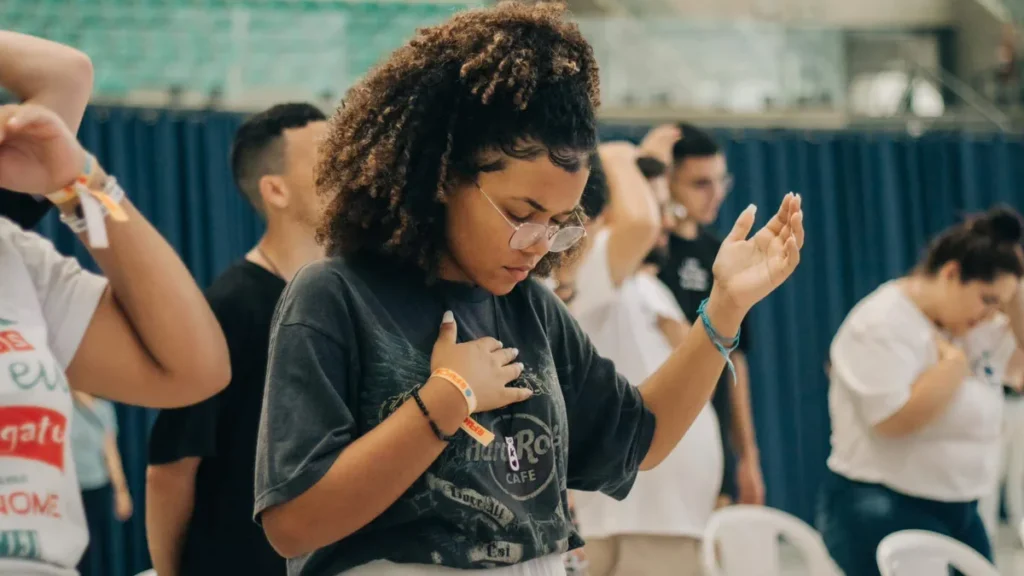 Imagem Mulher rezando do artigo Aparecida será palco do Geração Atômika 2023