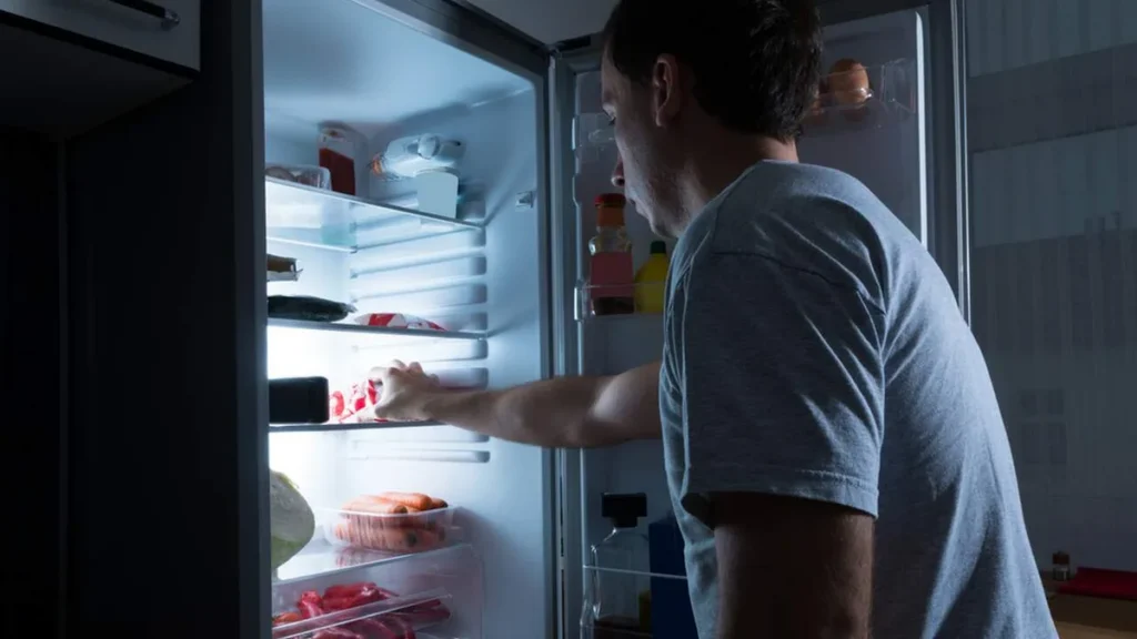 Imagem Homem atacando a geladeira de madrugada do artigo Conheça alguns padrões de comportamento que causam a fome noturna