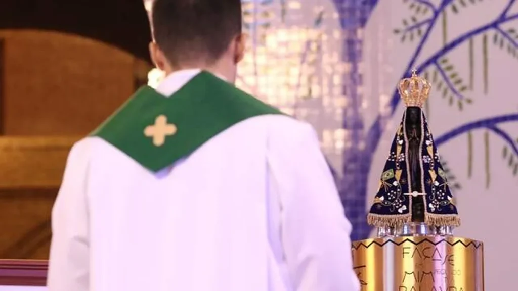 Imagem Imagem de Nossa Senhora Aparecida e um sacerdote do artigo "Maria, Mãe das vocações: um exemplo de amor e entrega ao chamado divino"