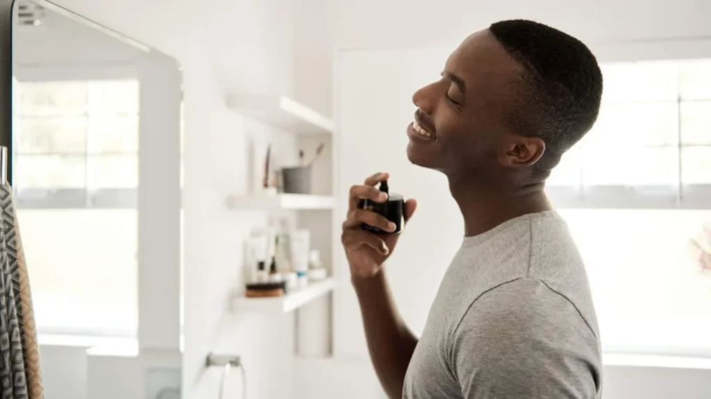 Imagem Auto cuidado masculino homem passa perfume do artigo Vaidade masculina: um mercado em ascensão