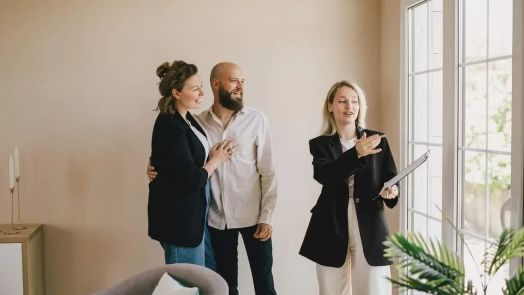 Imagem Corretora de Imoveis mostrando uma casa a um casal do artigo Corretor de imóveis: conheça mais sobre essa promissora profissão
