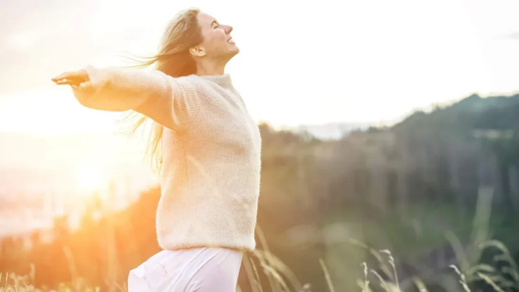 Imagem Mulher sorrindo celebrando a vida. Luz do Sol aparecendo do artigo Toda vida é preciosa