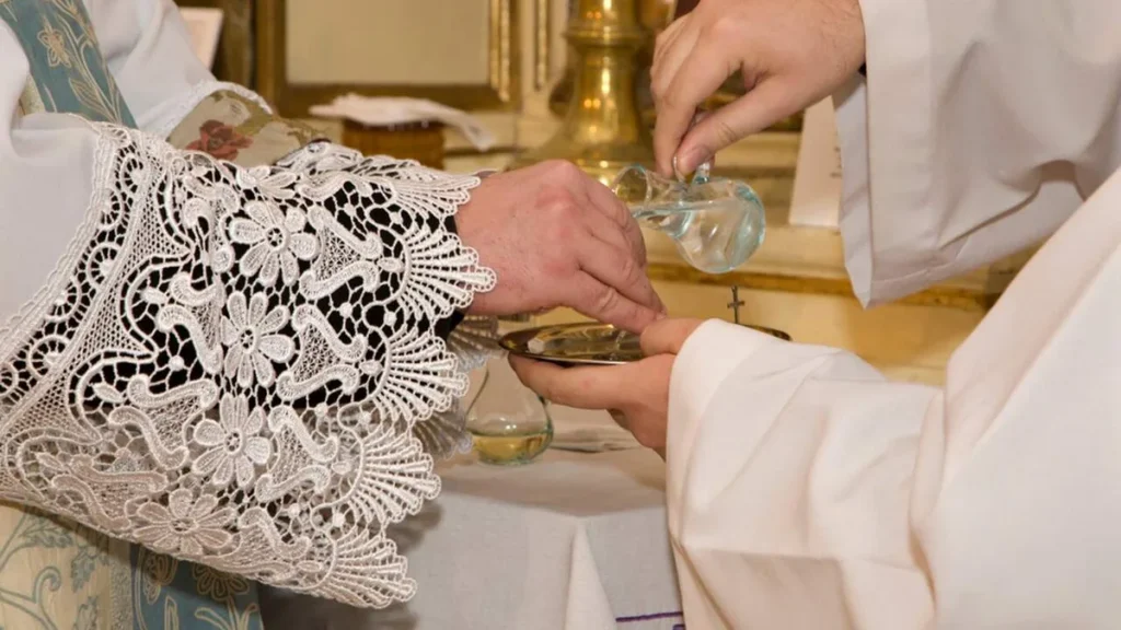 Imagem Padre lavando aos maos no momento do ofertorio do artigo Por que o padre lava as mãos após a preparação das oferendas?
