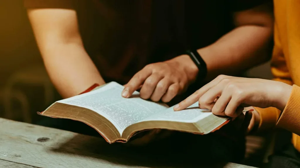 Imagem maos na Biblia do artigo Deus reconhece a todos da mesma maneira