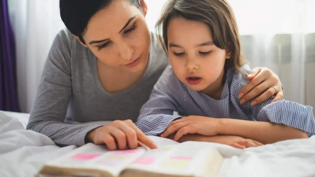 Imagem mulher ensinando crianca a ler a biblia do artigo Papa deseja a “alegria de encontrar Jesus” a quem participa da catequese