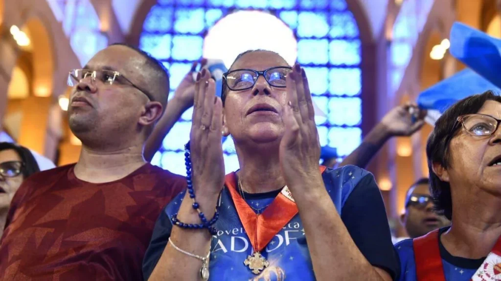Imagem Devotos rezam diante durante Missa Solene do artigo Como é a experiência do 12 de outubro em Aparecida?