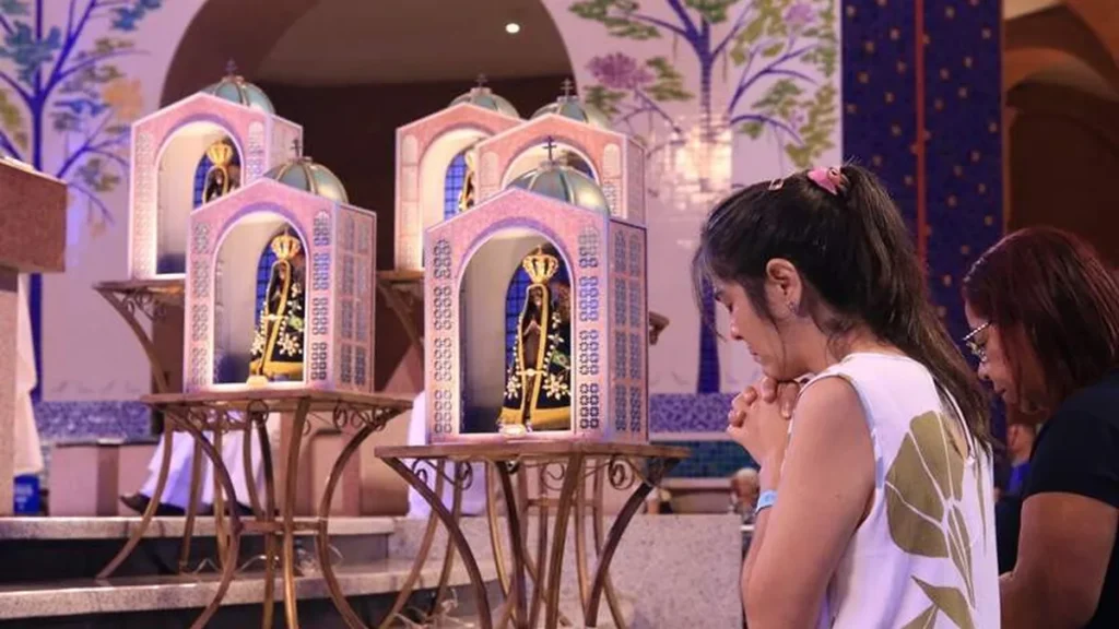 Imagem Devota reza diante das capelinhas Aparecida pelo Brasil do artigo Confiança, fé e obediência: as lições da devoção à Mãe Aparecida