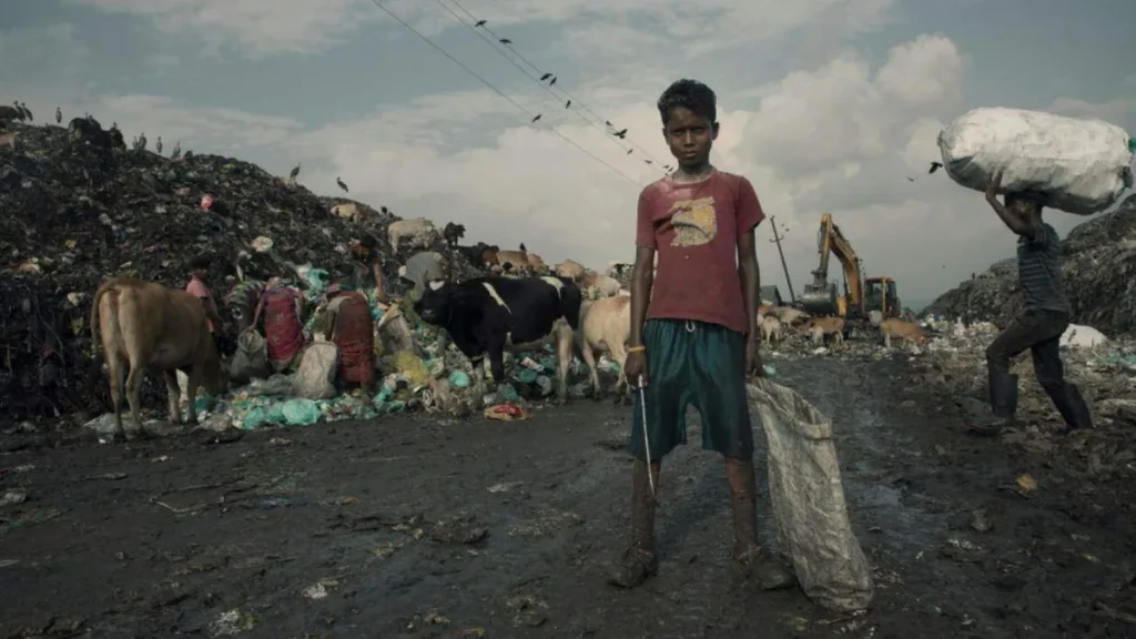 Imagem Menino no meio de um lixao com um saco de lixo na mao do artigo Dia Mundial dos Pobres encoraja o cuidado com os menos favorecidos