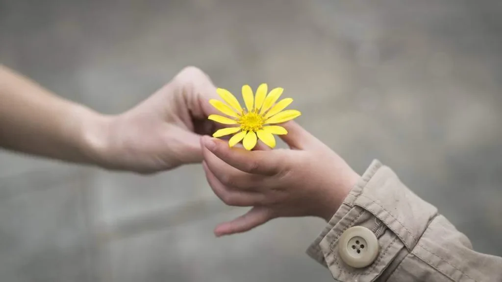 Imagem Maos entregando flores amarelas do artigo Sua generosidade espera algo em troca?