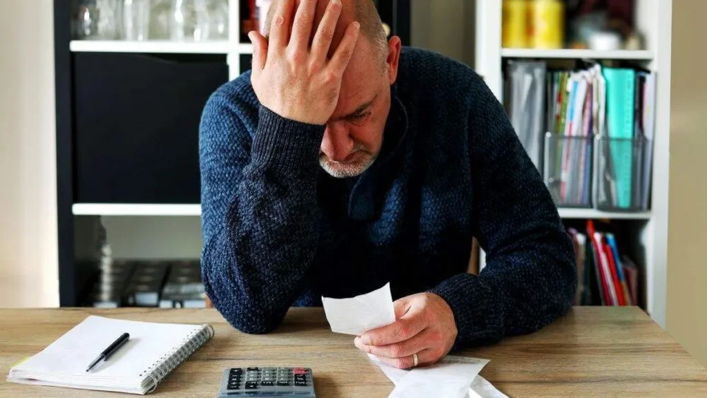 Imagem Homem pensativo com contas a pagar do artigo Ética e o consumo consciente: o caminho cristão