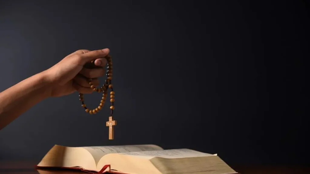 Imagem Mao segurando terco junto da Biblia do artigo O que são os “mistérios” do Rosário