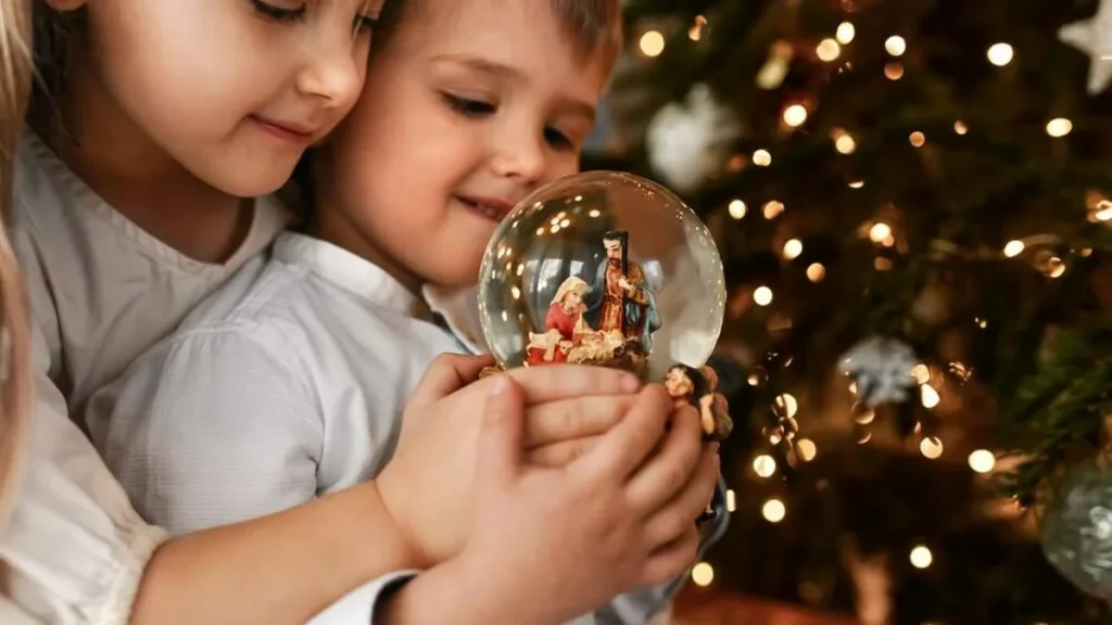 Imagem criancas olhando o presepio no globo do artigo Orações de Natal à espera do Menino Jesus