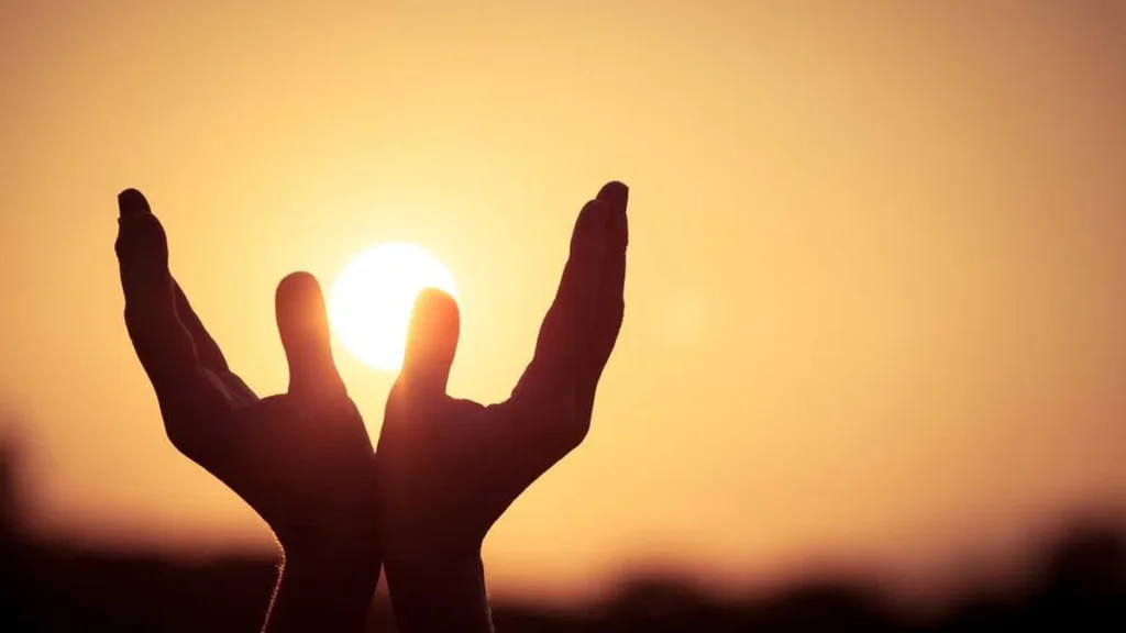 Imagem maos ao alto durante por do sol do artigo Oração de agradecimento pelo ano que termina