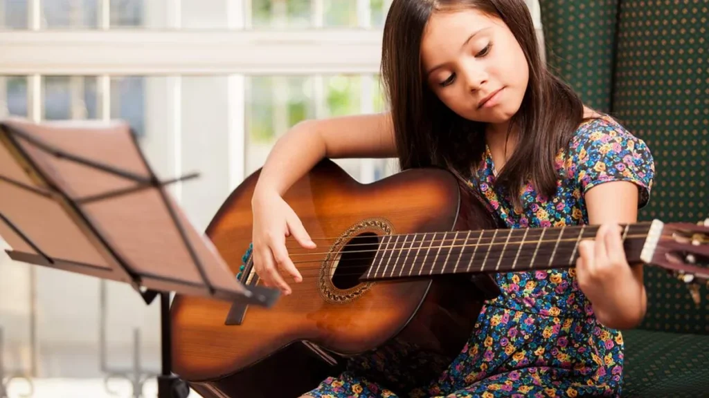 Imagem Menina aprendendo a tocar violao do artigo Projeto Guri oferece mais de 4 mil vagas para o Vale do Paraíba