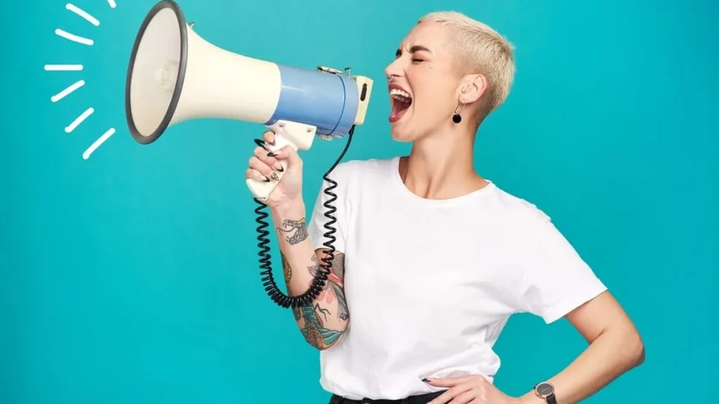 Imagem Mulher falando no megafone do artigo Semana da Mulher: 3 podcasts sobre a força feminina