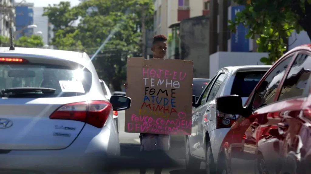 Imagem homem pedindo comida no transito do artigo A fome está diminuindo, mas ainda não desapareceu