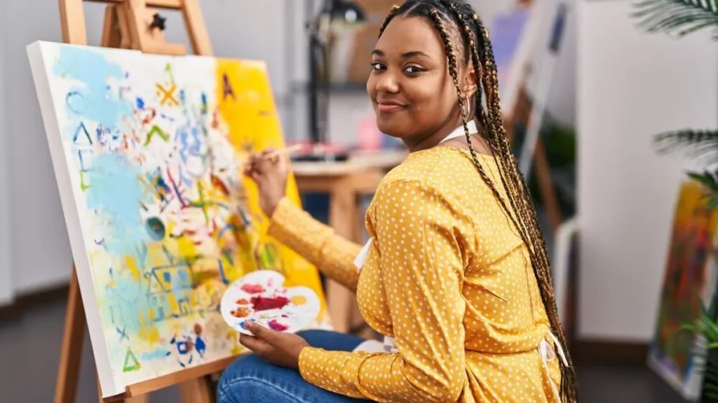 Imagem jovem mulher pintando um quadro do artigo 5 Santos padroeiros de hobbies comuns a nós