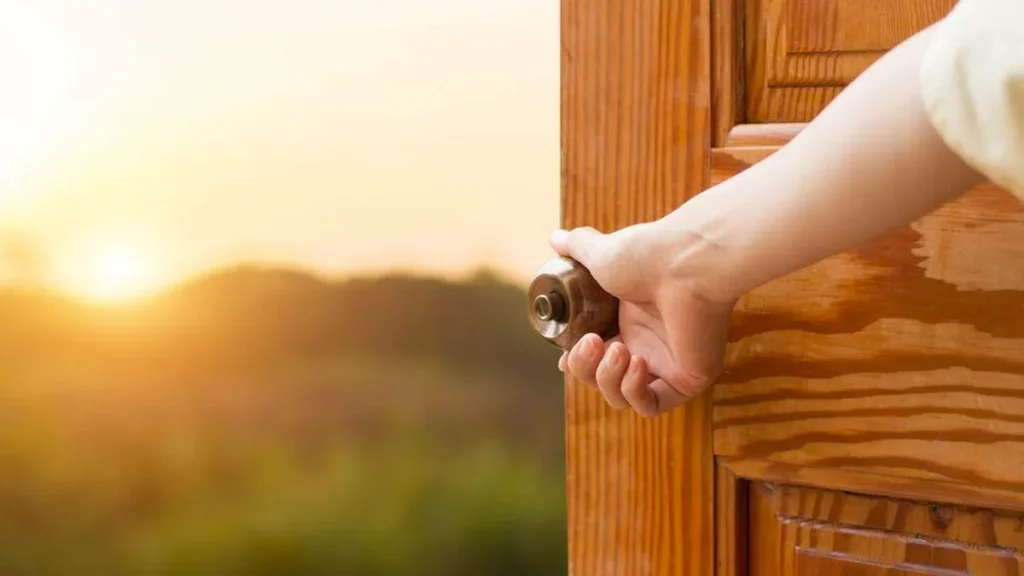 Imagem Maos abrindo a porta do artigo Quando Nossa Senhora bate à sua porta, você abre?