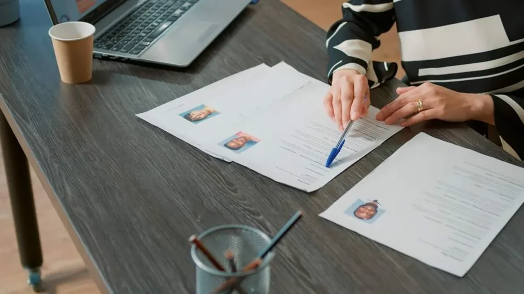 Imagem Mulher analisando curriculos do artigo Aprenda a construir um currículo eficiente e competitivo