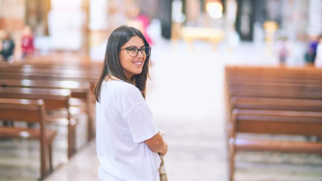Imagem moca sorrindo dentro da igreja do artigo 5 passos para crescer em santidade segundo o Evangelho
