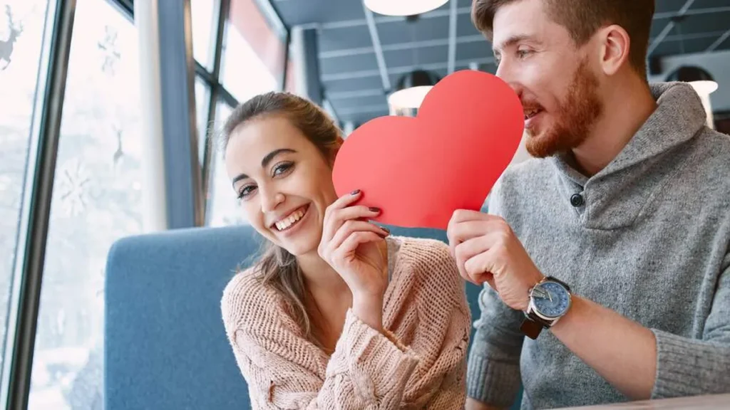 Imagem casal de namorados segurando um coracao vermelho do artigo Pode o católico namorar alguém de outra religião?