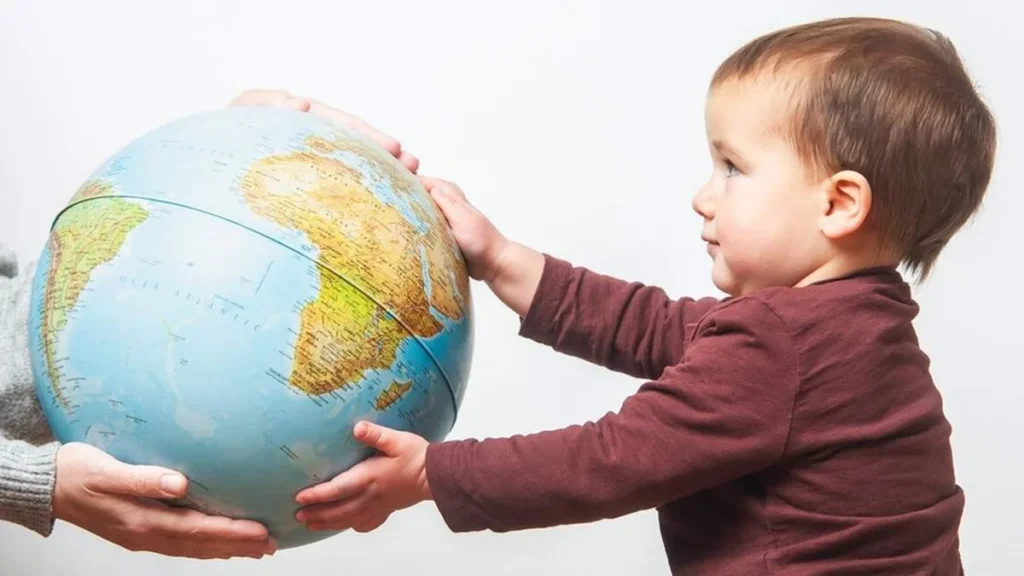 Imagem Bebe segurando o globo mundial do artigo Como o marco de 8 Bilhões de pessoas reflete a urgência de cuidar da vida