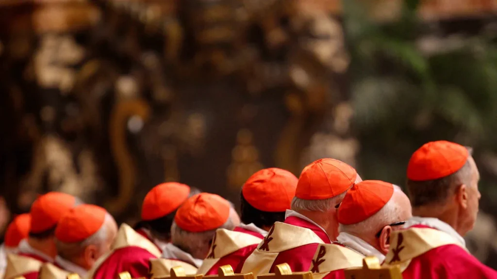 Imagem cardeais da Igreja Catolica sentados de costas do artigo Você sabe como é escolhido o cardeal que diz “Habemus Papam”?