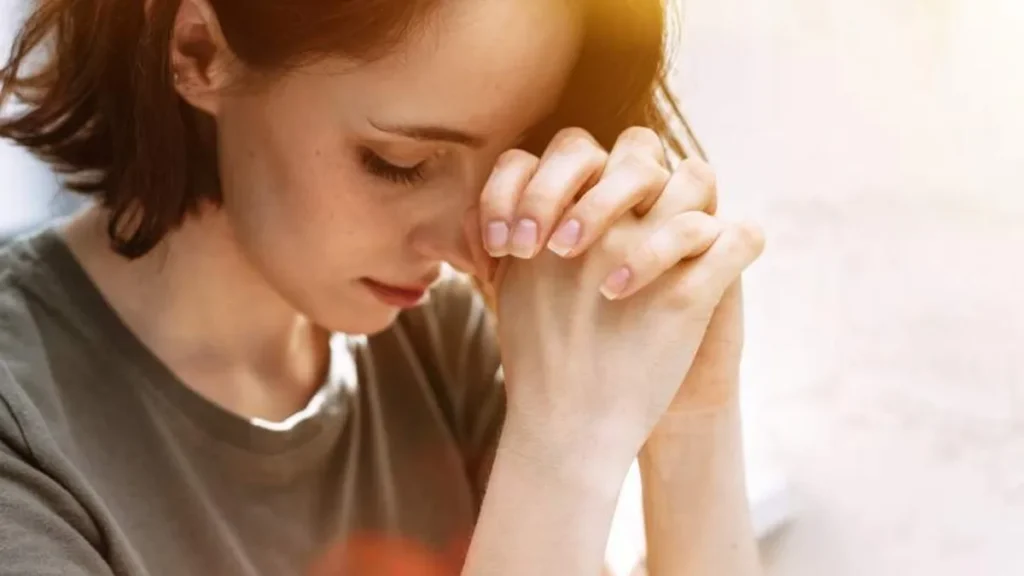 Imagem Mulher com as maos em oracao do artigo A importância do silêncio na vida espiritual: aprendendo a ouvir a Voz de Deus