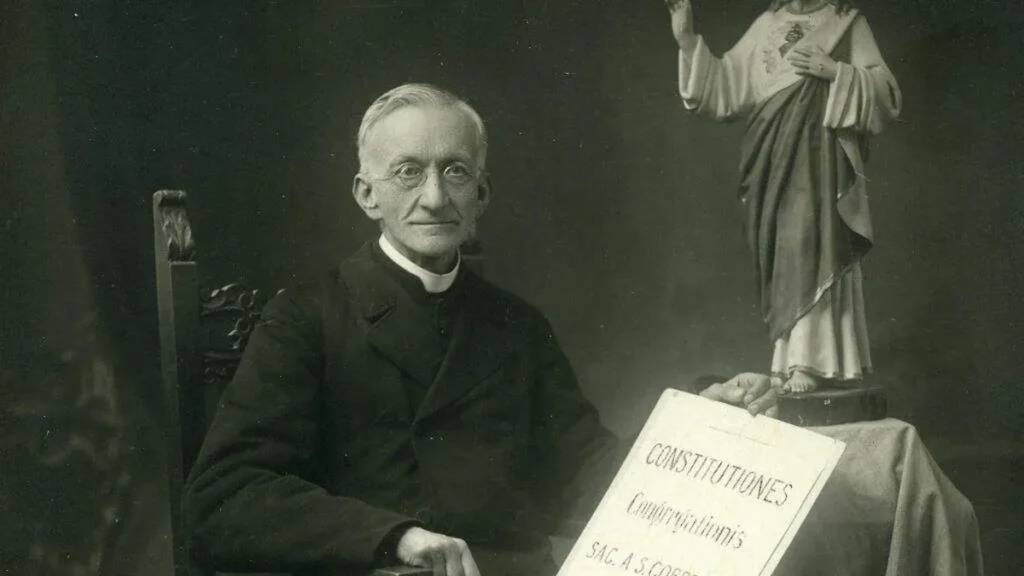 Imagem padre Dehon sentado ao lado da imagem do Sagrado Coracao de Jesus do artigo Dehonianos preparam celebração do centenário de falecimento de seu fundador