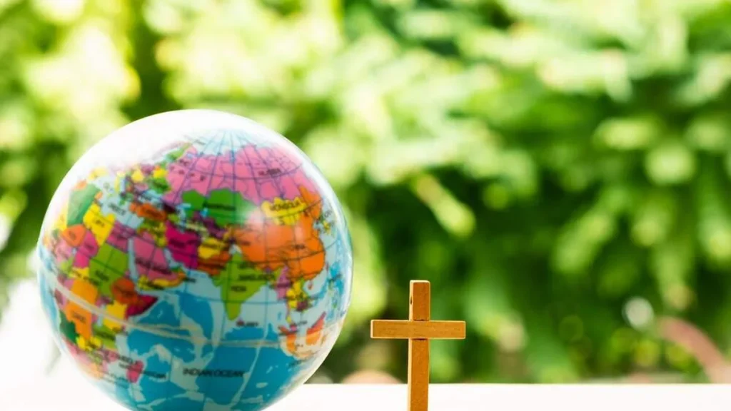 Imagem globo terrestre com uma cruz ao lado do artigo Encontro de catequese para celebrar o Mês Missionário