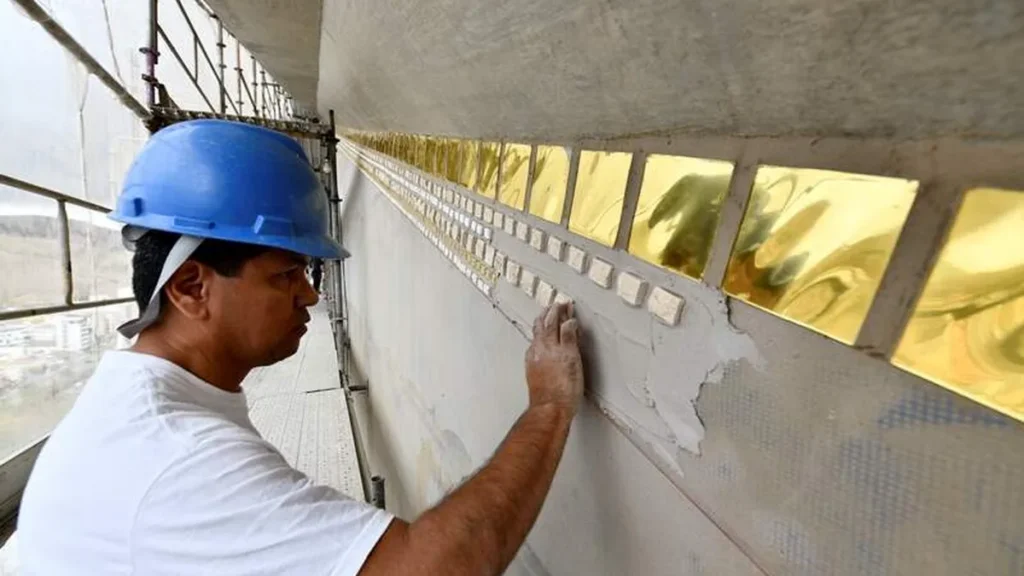 Mosaicista aplica mosaico na Fachada Leste