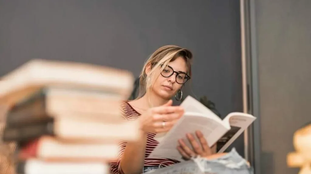 Imagem Mulher lendo livros do artigo Aprofundando o conhecimento real