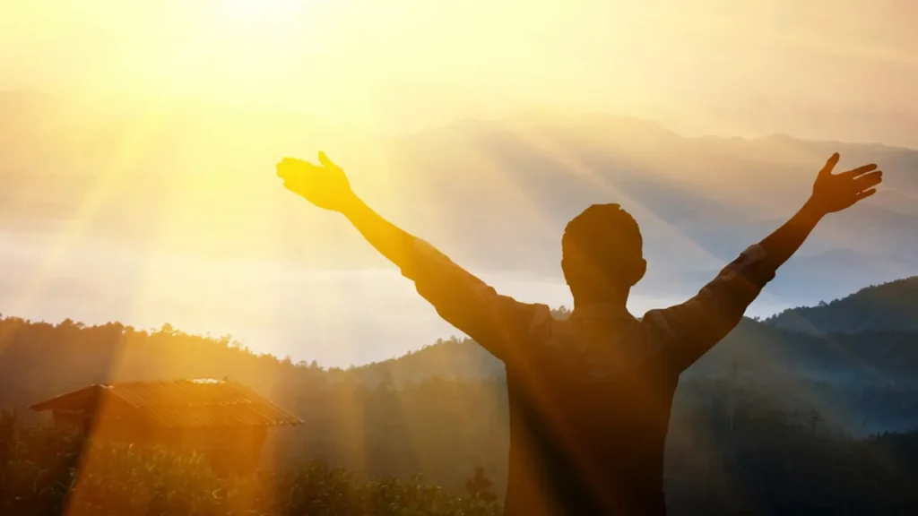 Imagem pessoa erguendo os bracos para o alto e louvando a Deus do artigo Oração para ouvir a voz de Deus na vida